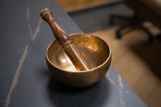 Cuenco tibetano sobre superficie de mármol — detalle del ritual de relajación